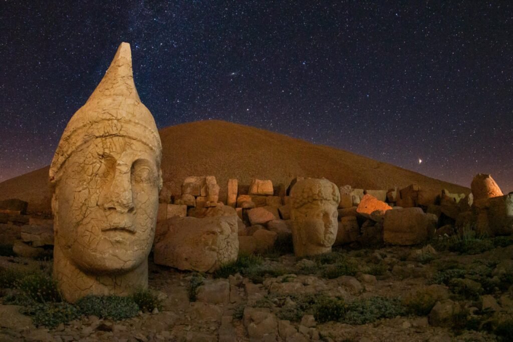 Captivating view of ancient statues on Mount Nemrut under a starry night in Adıyaman, Turkey.