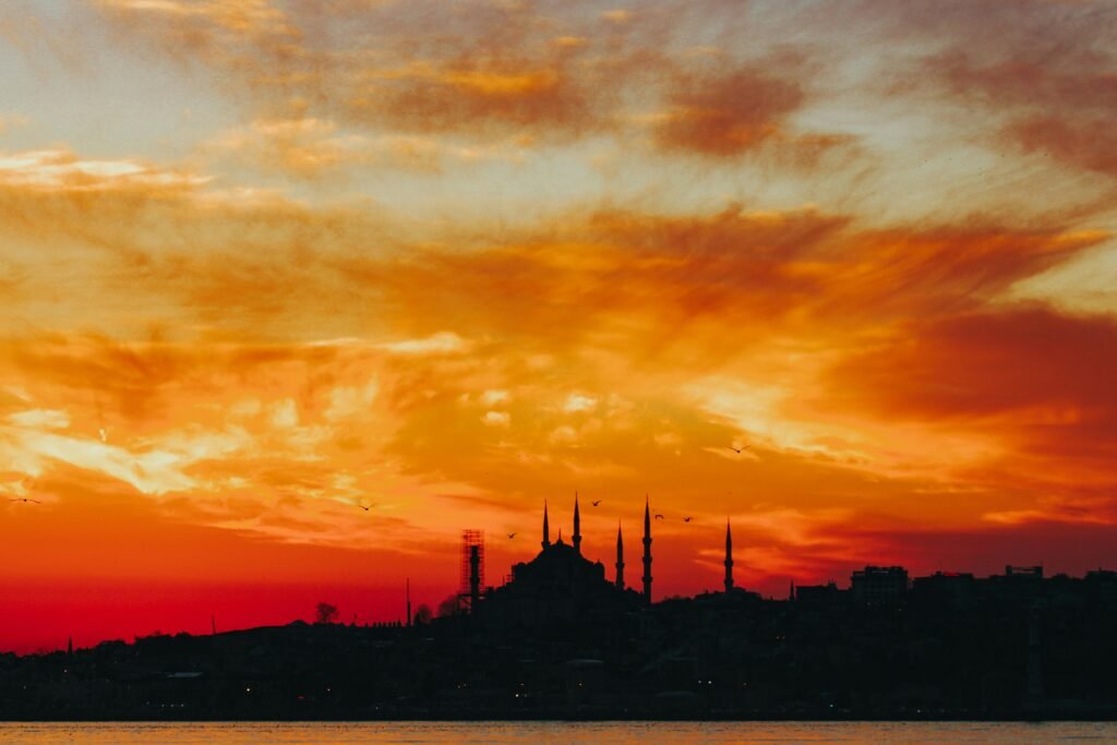 Dramatic silhouette of a mosque against a vibrant sunset sky in Istanbul, Turkey.